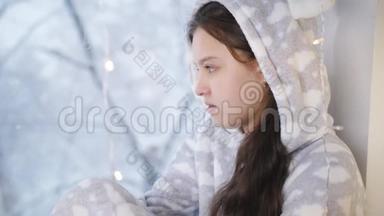 少女温特穿着暖和的睡衣和围巾坐在窗边，看起来<strong>窗外</strong>正在<strong>下雪</strong>。